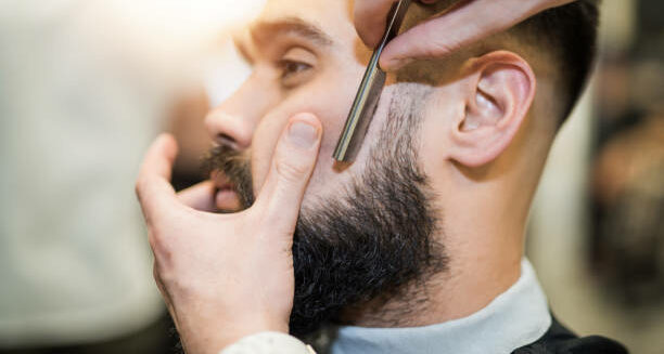 Young man getting his beard freshly cut.